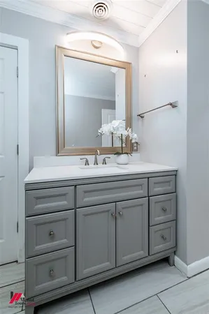 a bathroom with a sink vanity and mirror