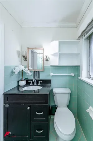 a bathroom with a toilet sink and mirror