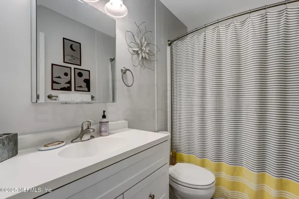 a bathroom with a sink a toilet and shower curtain