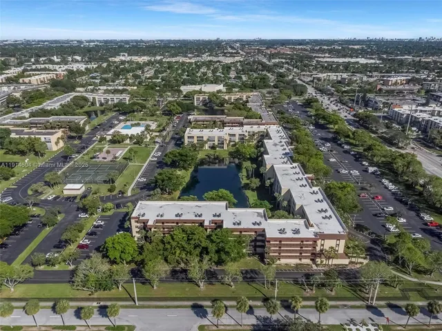 an aerial view of residential houses with outdoor space and trees