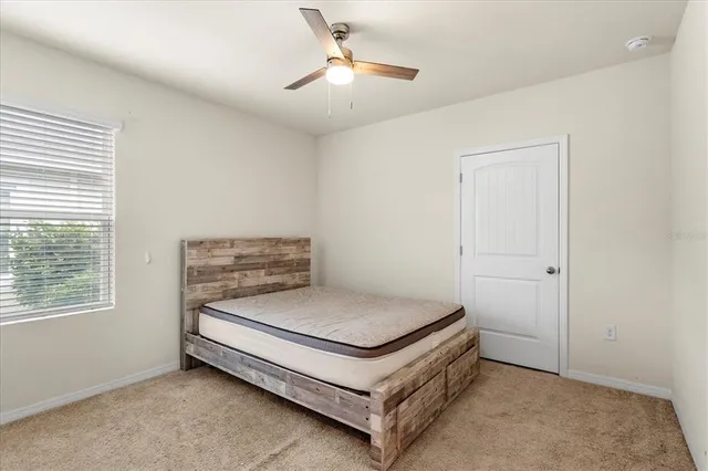a bedroom with a bed and a ceiling fan