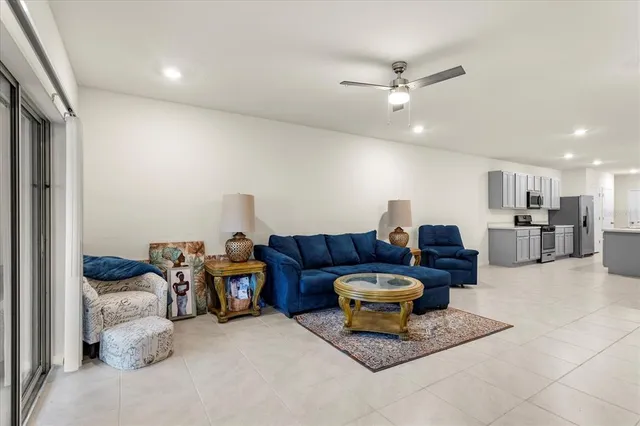 a living room with furniture a ceiling fan and a rug