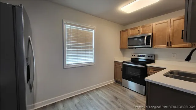 a kitchen with stainless steel appliances a stove microwave and sink