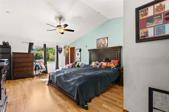 a bedroom with a bed and a flat tv screen on the dresser