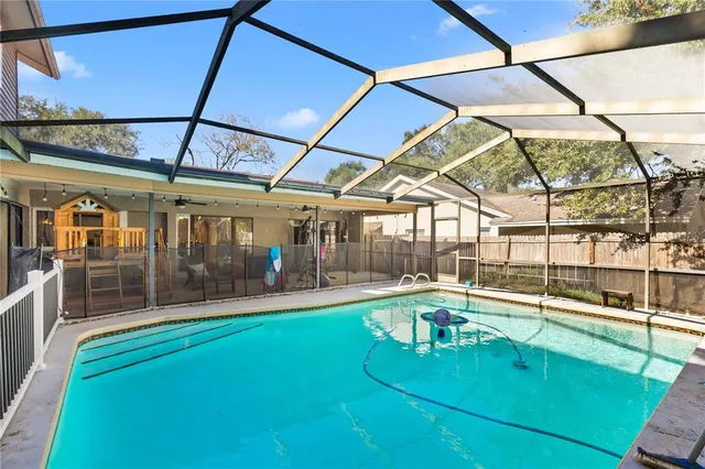 a view of a swimming pool with a patio and a yard