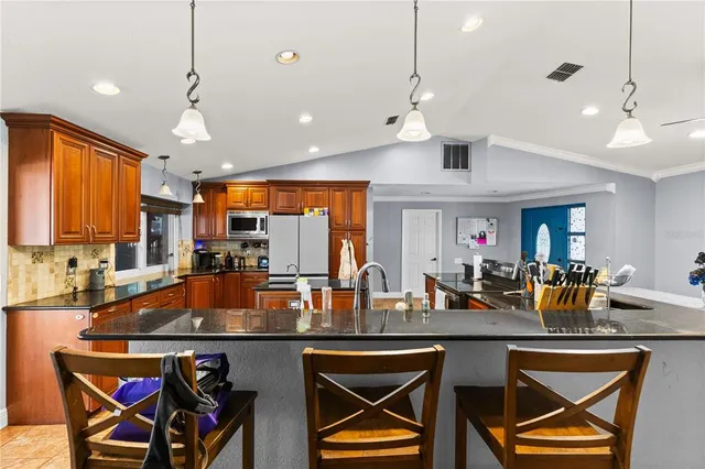 a kitchen with a dining table chairs sink and cabinets