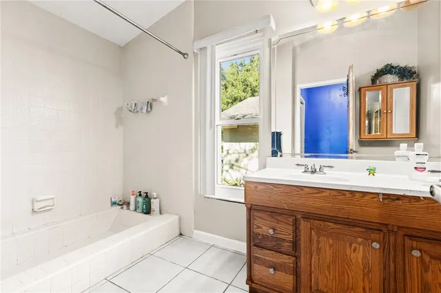 a bathroom with a bathtub a sink and a mirror