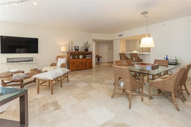 a large white kitchen with granite countertop a large counter top space and stainless steel appliances