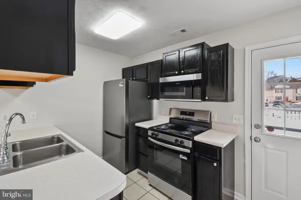 a kitchen with stainless steel appliances a refrigerator a sink and a stove