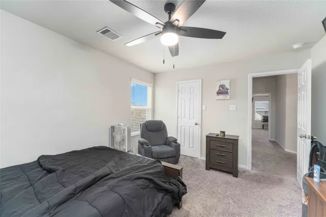 a bedroom with furniture and a ceiling fan
