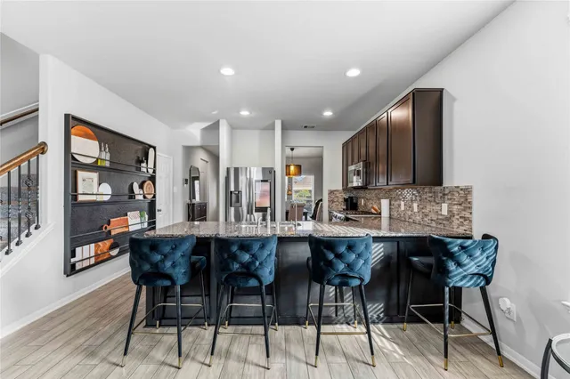 a dining area with stainless steel appliances a table and chairs