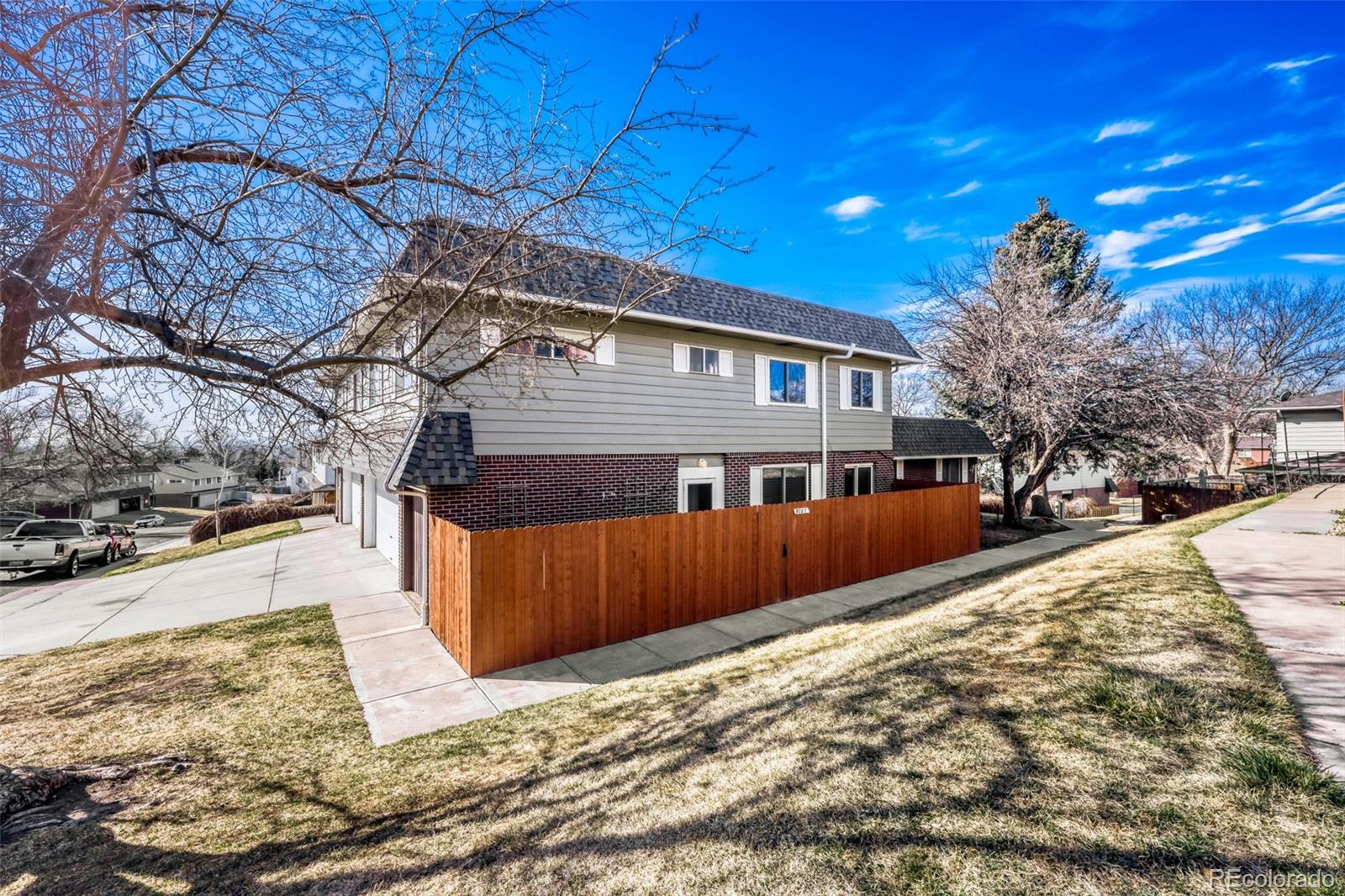 9787 Lane Street Thornton, CO 80260 - Photo 1 of 29 a view of a house with a yard covered in snow