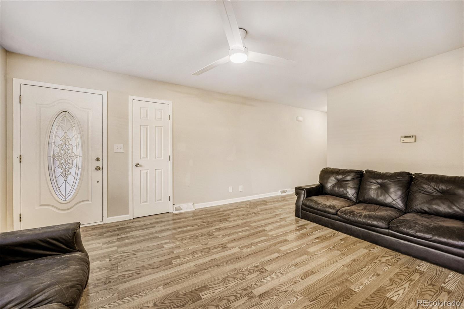 9787 Lane Street Thornton, CO 80260 - Photo 2 of 29 a living room with a couch and a dresser