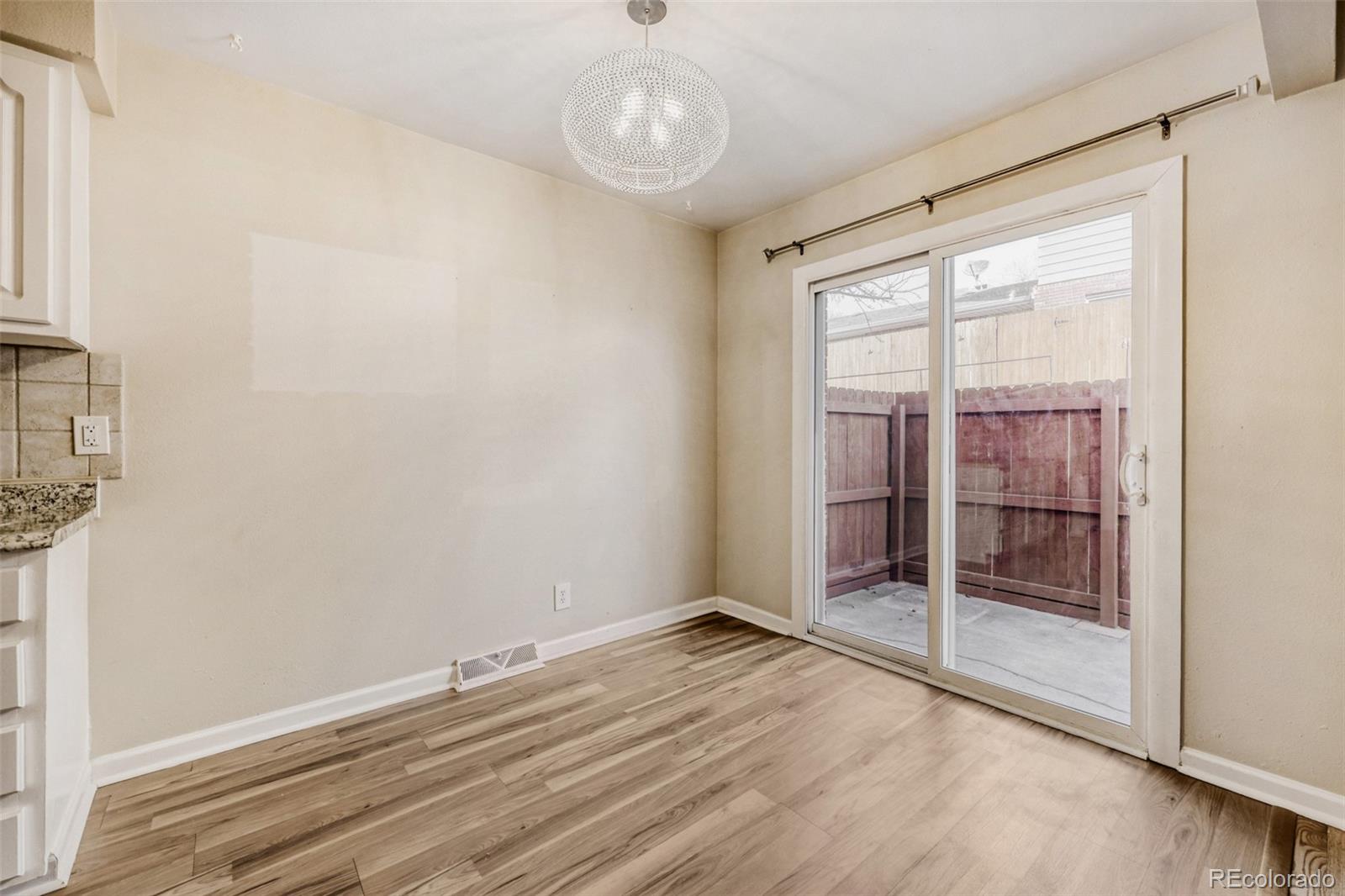 9787 Lane Street Thornton, CO 80260 - Photo 5 of 29 a view of an empty room with wooden floor and a window