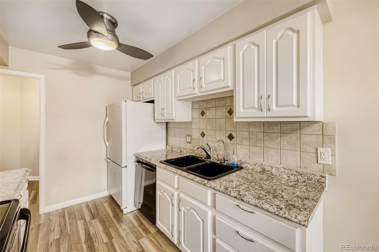 9787 Lane Street Thornton, CO 80260 - Photo 7 of 29 a kitchen with stainless steel appliances granite countertop white cabinets and a stove