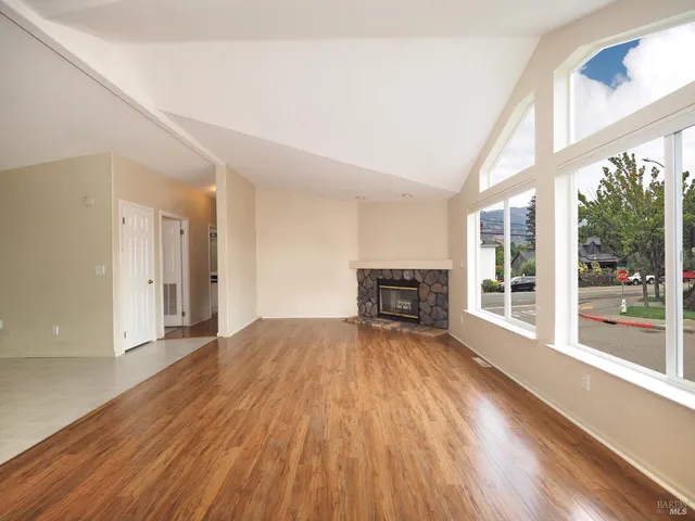 a view of empty room with wooden floor and fireplace