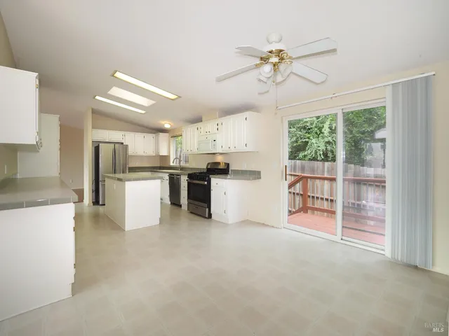 a view of kitchen with sink a refrigerator and cabinets