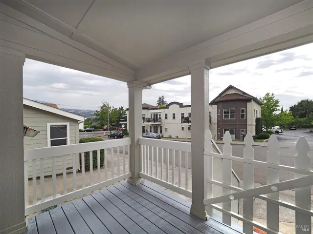 a view of a balcony with wooden floor and fence