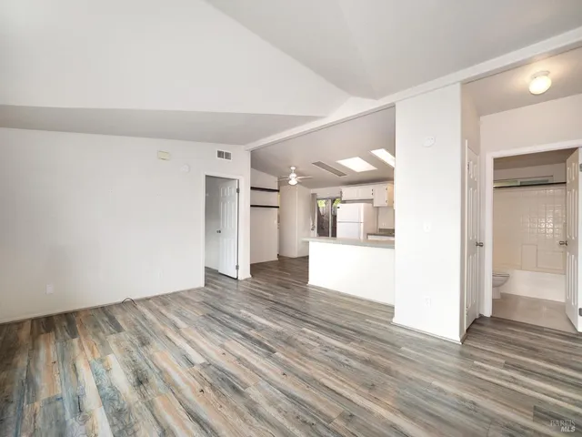 a view of an empty room with wooden floor