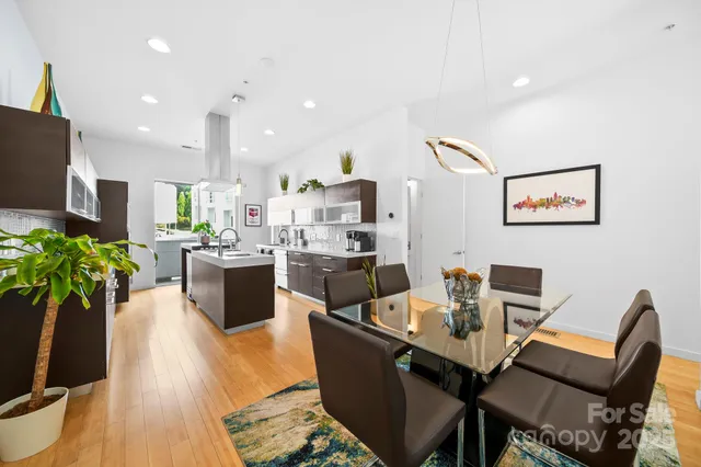 a living room with furniture kitchen view and a potted plant