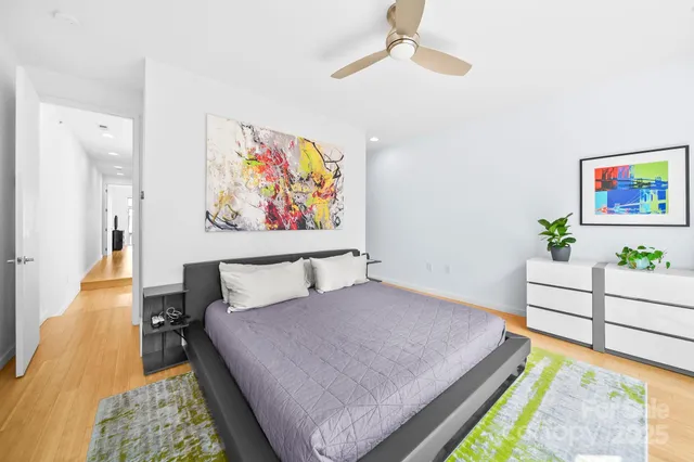 a bed room with a bed and a painting on the wall