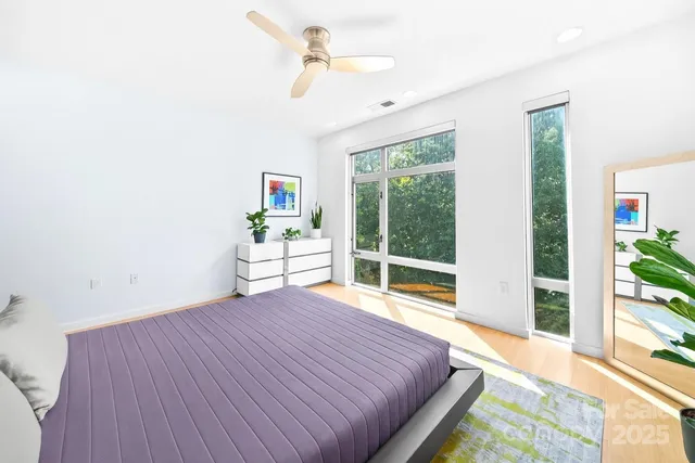 a bedroom with a bed and a large window with outer view