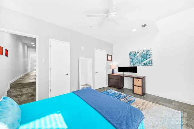 a bedroom with a bed and a view of kitchen