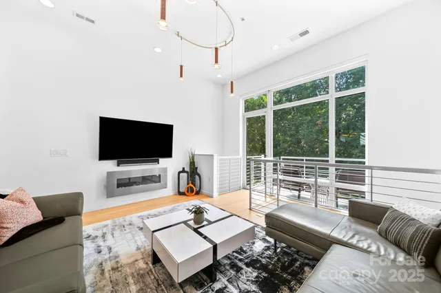 a living room with furniture a flat screen tv and a large window