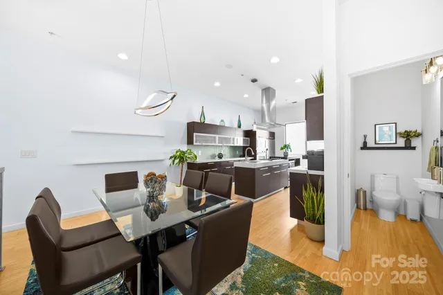 a dining room with furniture a rug and kitchen view