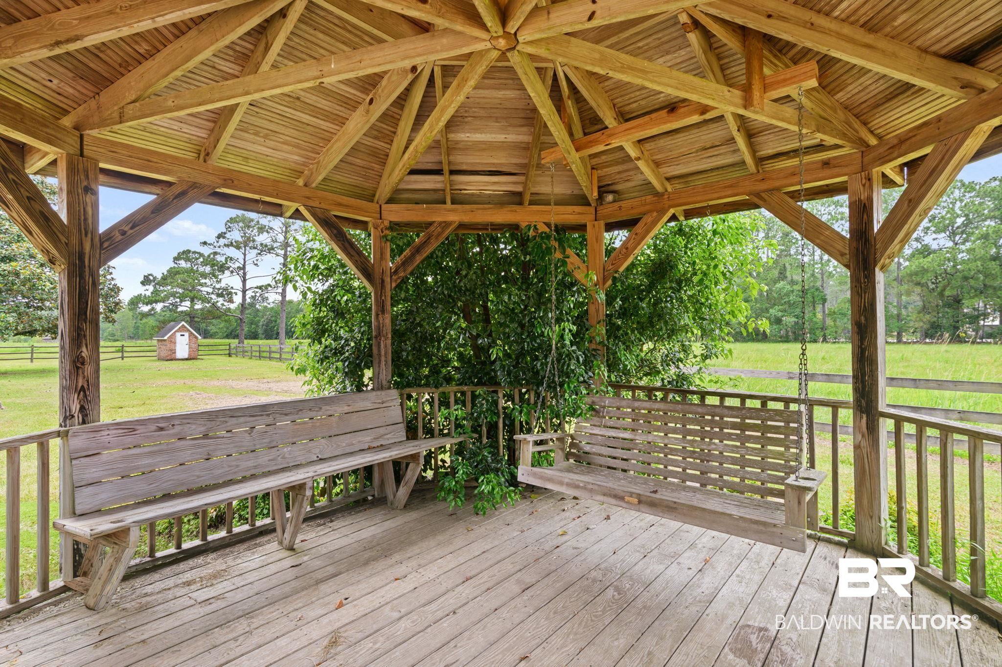 7540 2 Mile Road Irvington, AL 36544 - Photo 68 of 82 Wooden gazebo featuring a slatted ceiling, exposed beams, and a built-in wooden bench