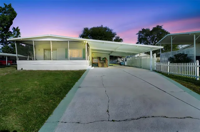 a front view of a house with a yard and potted plants