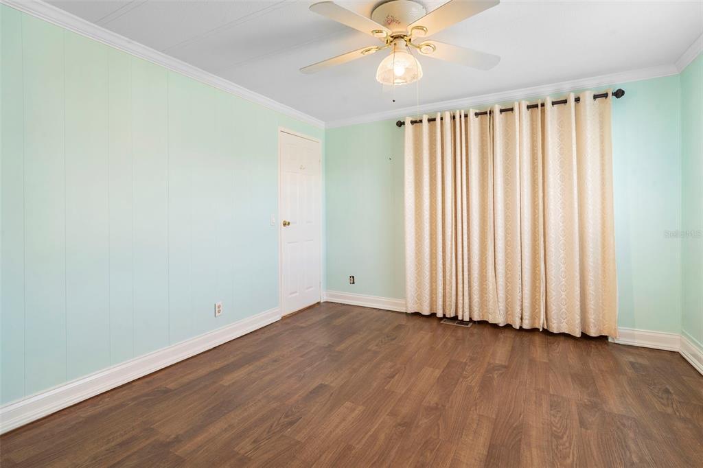 105 Florence Boulevard DeBary, FL 32713 - Photo 10 of 31 an empty room with wooden floor fan and windows