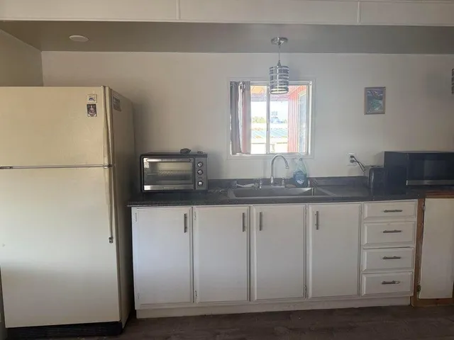 a kitchen with granite countertop cabinets and refrigerator
