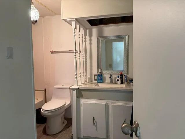 a bathroom with a toilet sink and mirror