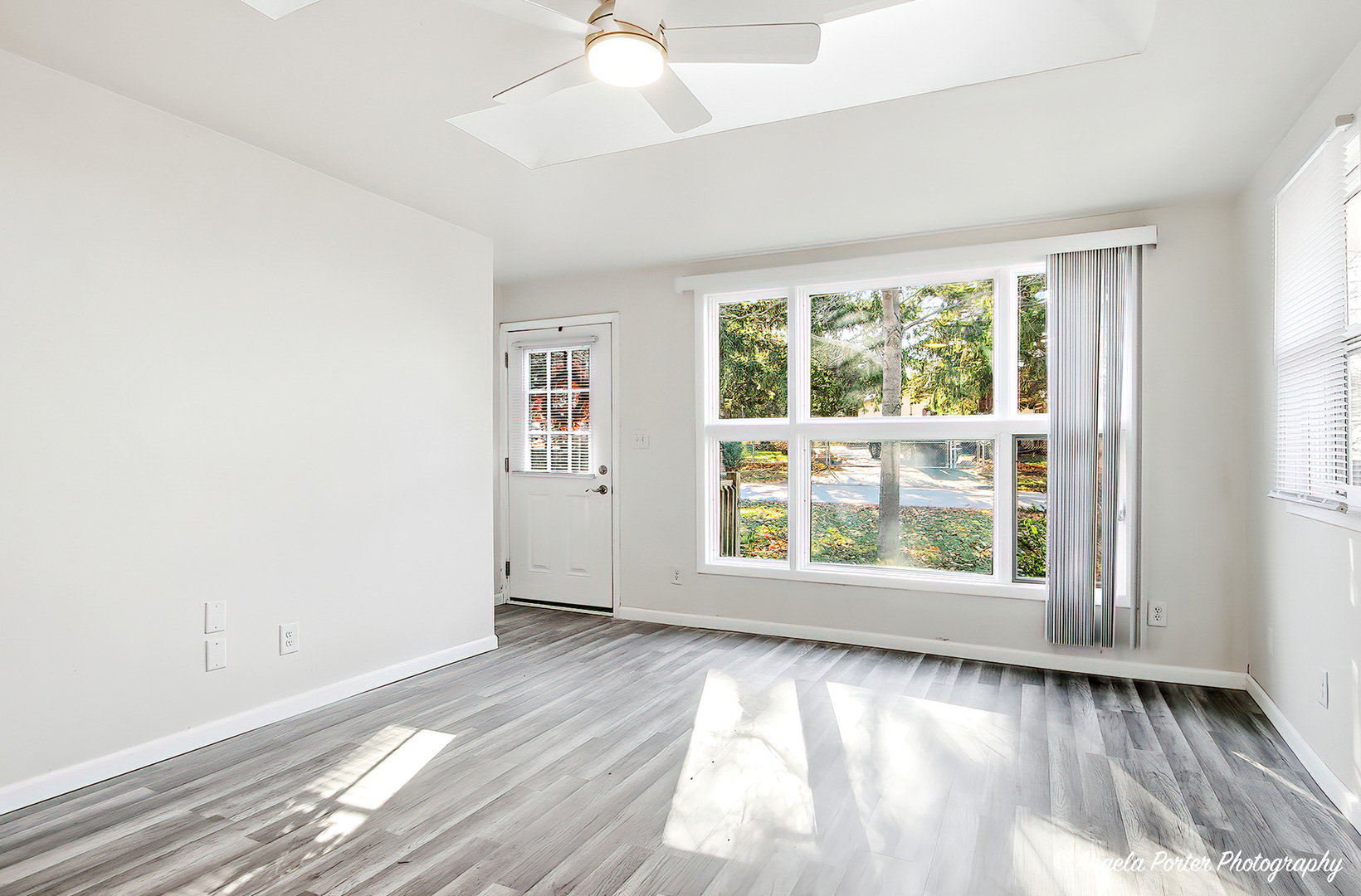 24676 West Clinton Avenue Round Lake, IL 60073 - Photo 4 of 28 an empty room with wooden floor and windows