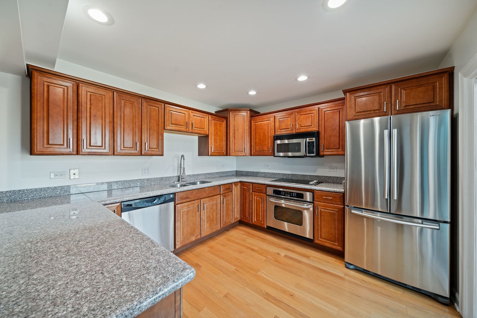 613 Dunham Road, Unit 613 Gurnee, IL 60031 - Photo 5 of 27 a kitchen with stainless steel appliances granite countertop a refrigerator stove sink and microwave