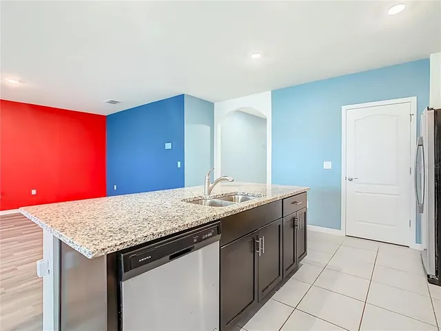 a utility room with granite countertop cabinets and entryway
