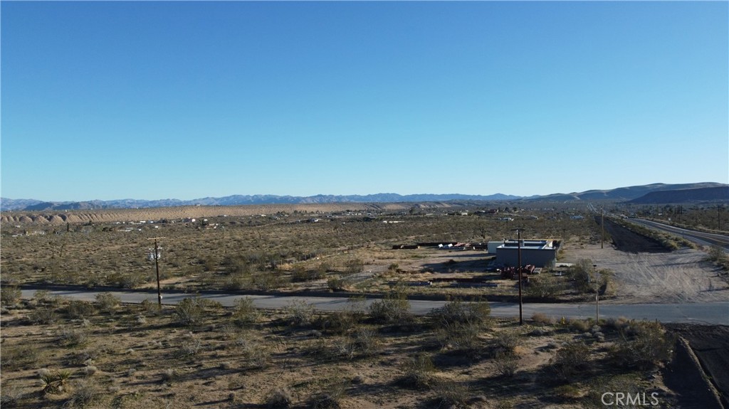 0 Old Woman Springs Road Yucca Valley, CA 92284 - Photo 4 of 10 a view of a dry yard with wooden floor and mountains