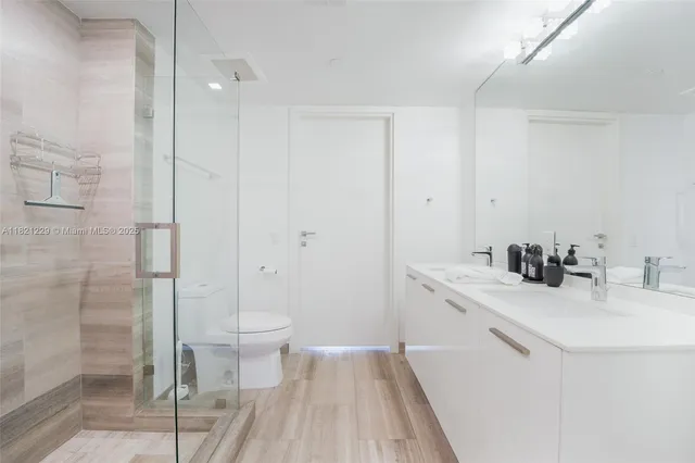 a bathroom with a sink a toilet and shower