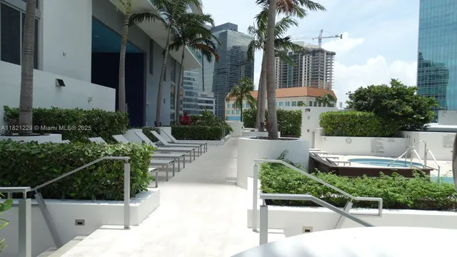 a view of a patio with couches table and chairs potted plants and palm tree
