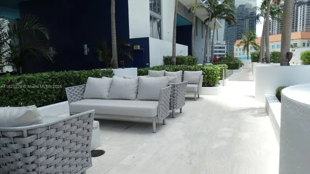 a view of a patio with couches and a fire pit and wooden fence