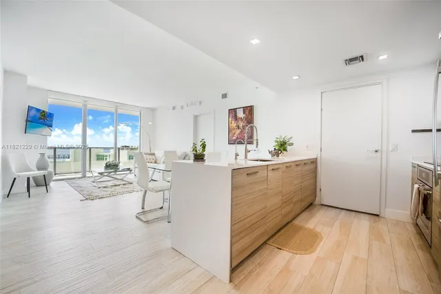 a view of a kitchen with furniture and wooden floor