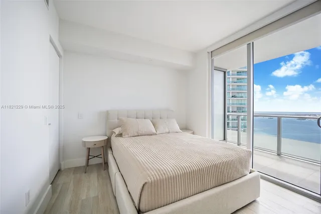 a bedroom with a bed and a view of balcony