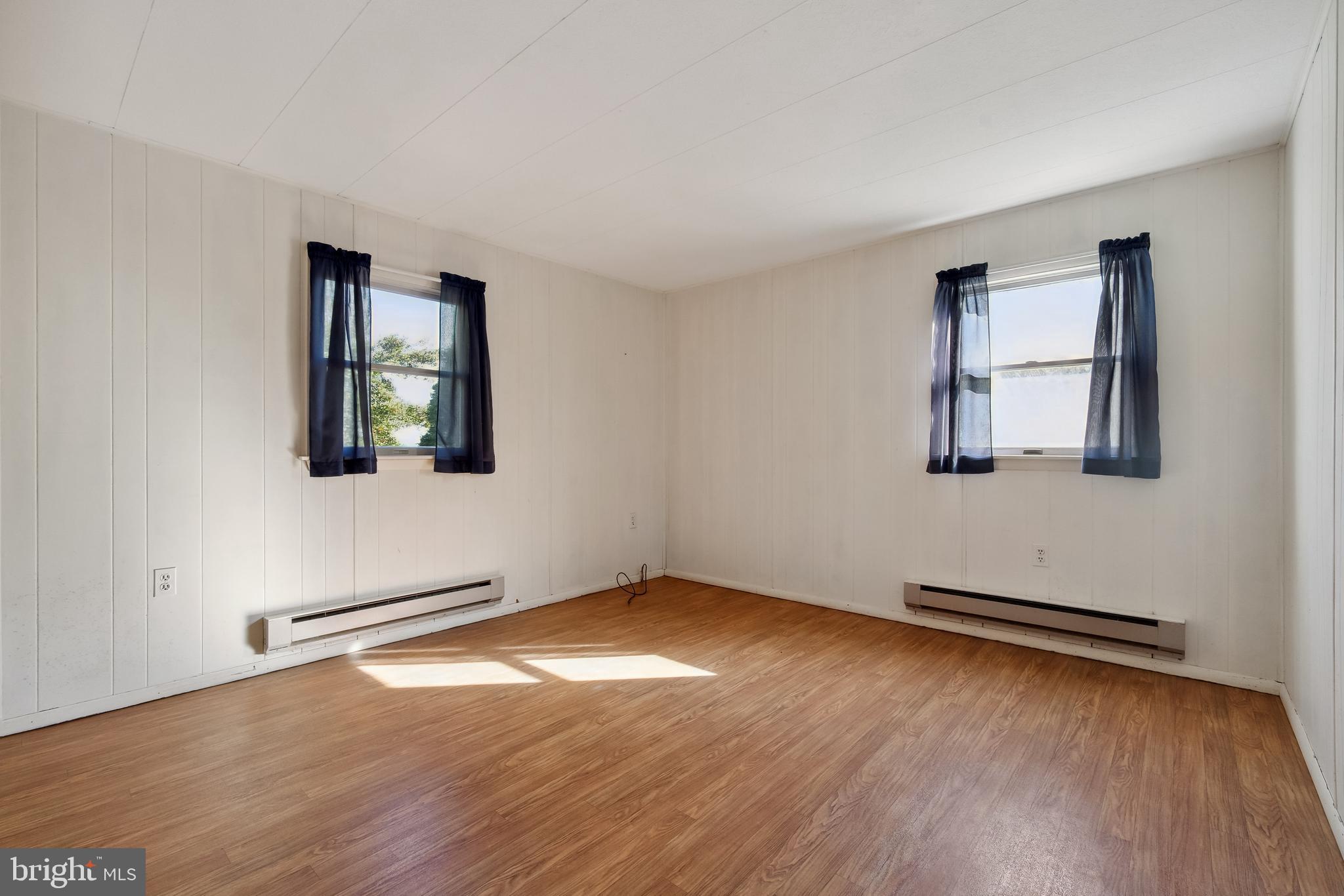 1106 Round Top Road Chestertown, MD 21620 - Photo 14 of 27 an empty room with wooden floor and windows