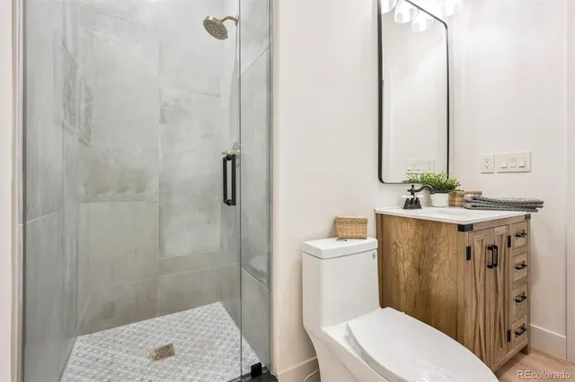 a bathroom with a sink a toilet a mirror and shower