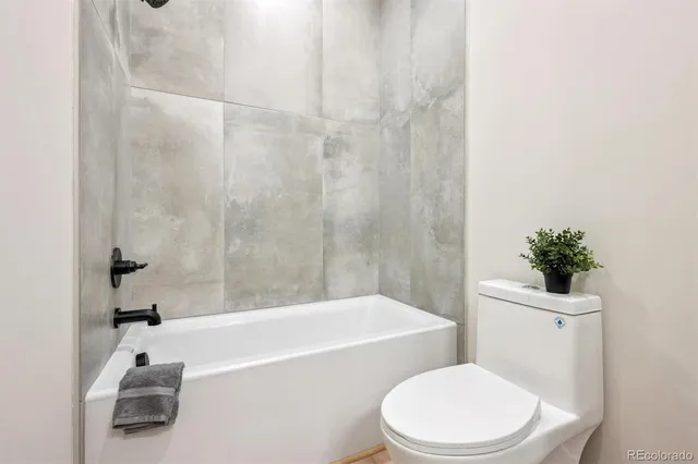 a white toilet sitting next to a bath tub