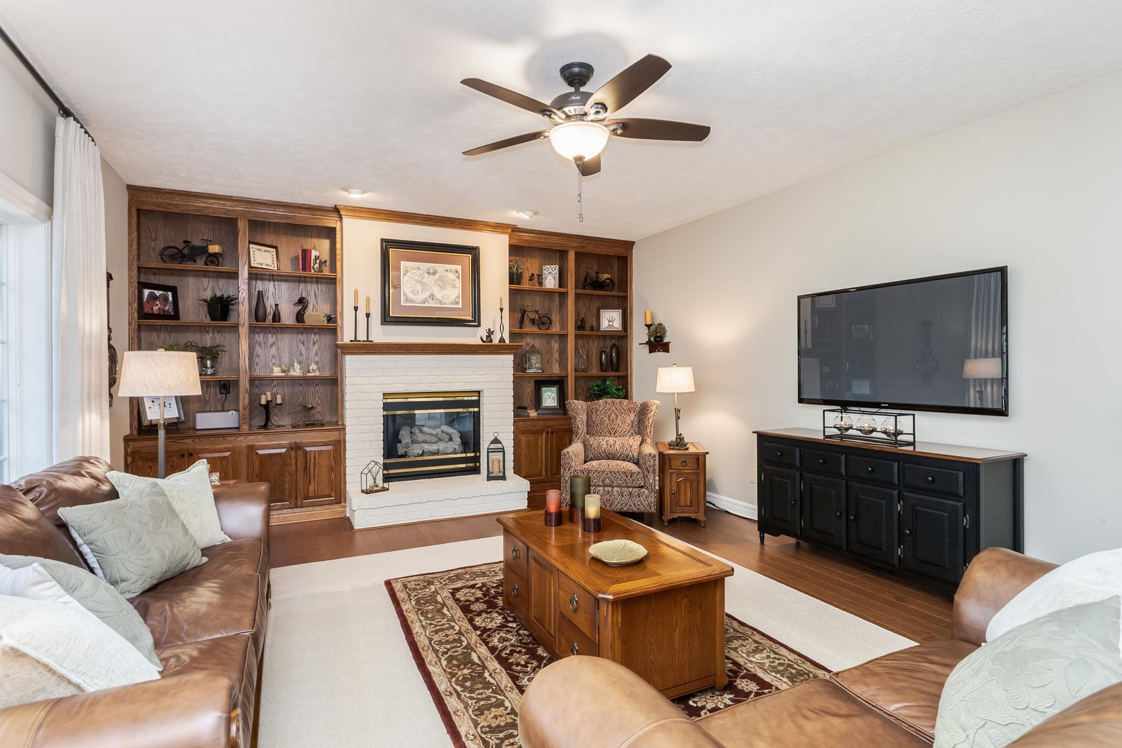 2006 Woodbine Road Bloomington, IL 61704 - Photo 33 of 98 a living room with furniture a flat screen tv and a fireplace