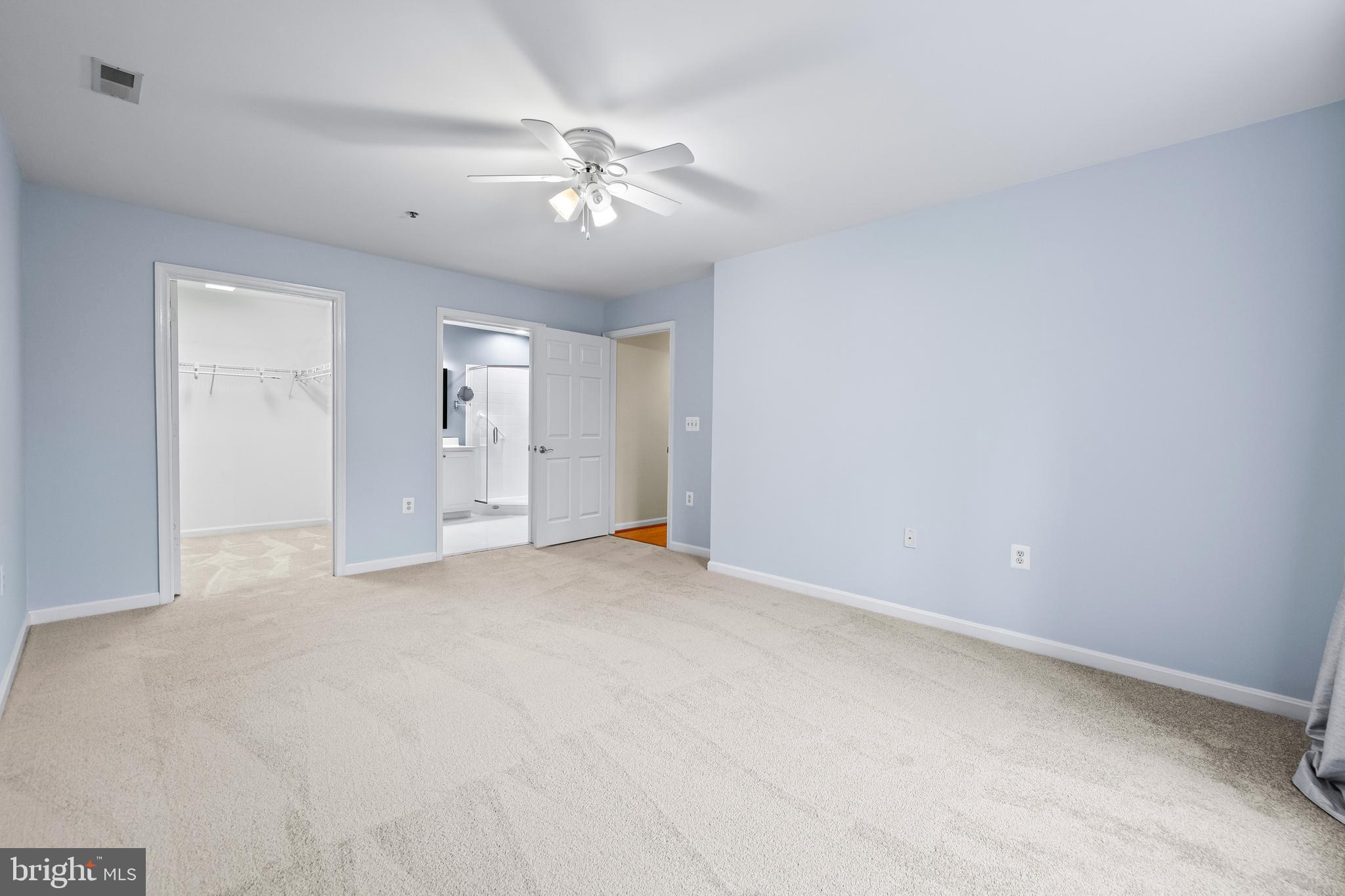 12011 Tralee Road, Unit 104 Lutherville-Timonium, MD 21093 - Photo 17 of 33 an empty room with chandelier fan and windows
