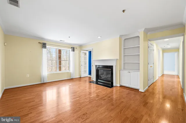 a view of an empty room with window and fire place