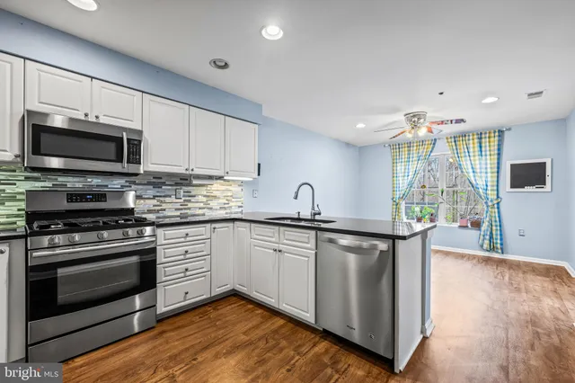 a kitchen with stainless steel appliances granite countertop a stove a sink and a microwave
